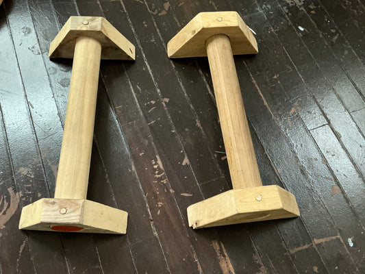 Hand-routed 2-inch thick wooden parallettes for grip strength training by Rough Road Fitness.